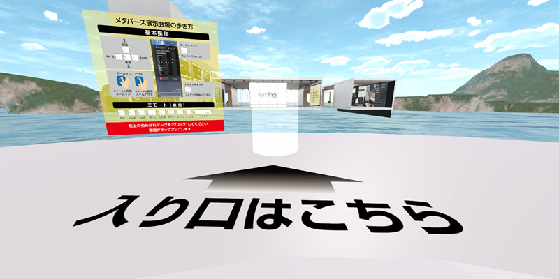 ２、「⼊⼝はこちらから」の⽩い円筒にお進みください。展⽰会場にワープします